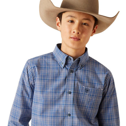Boy's Ariat long sleeve shirt in True Blue Plaid. Close up of view of front showing button down collar and Ariat shield logo on left chest pocket.