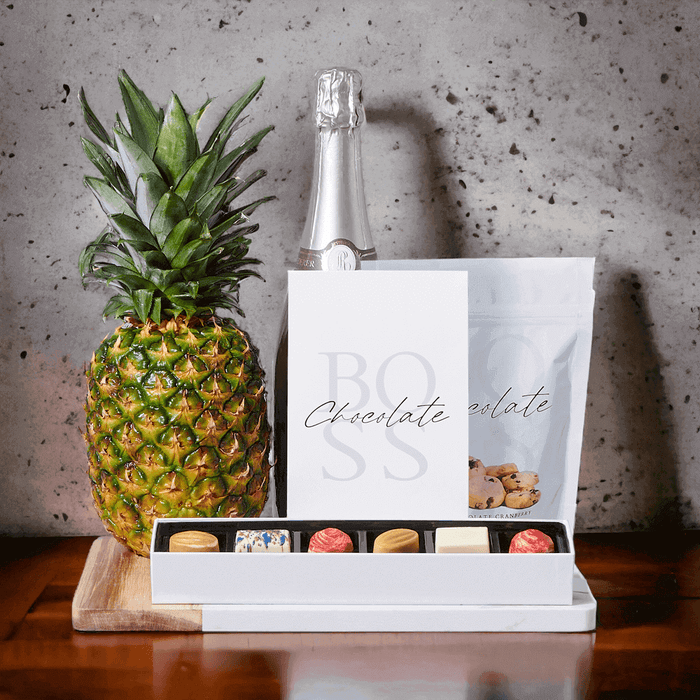 The Grand Sparkling Wine & Pineapple Gift Set, we intend to make the moment even more special for your loved ones. The gift set features attractive gifts like a beautifully fresh pineapple, milk chocolate caramels, white chocolate cranberry shortbread cookies, white chocolate truffles, and a marble & wood serving board.